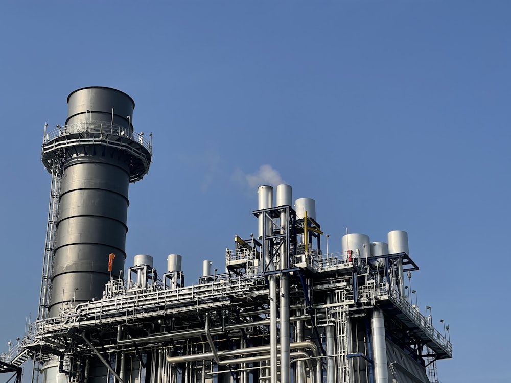 usine grise et noire sous le ciel bleu pendant la journée