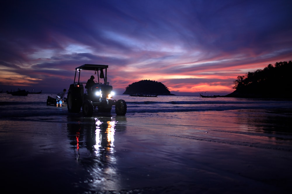 Silhouette des Lastwagens auf dem Wasser bei Sonnenuntergang