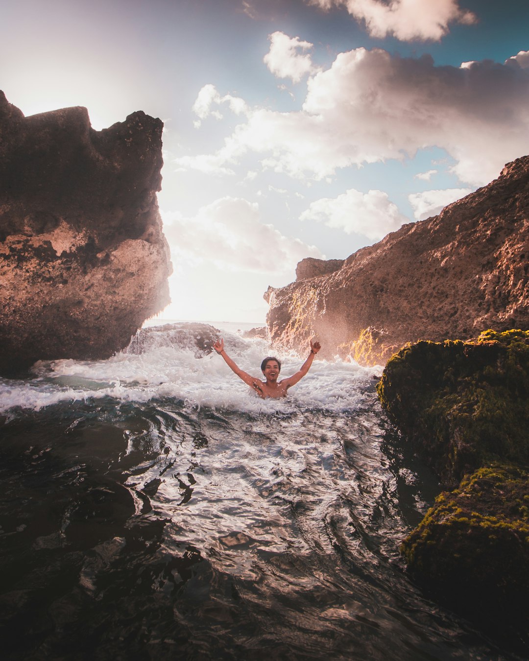 man in water falls during daytime