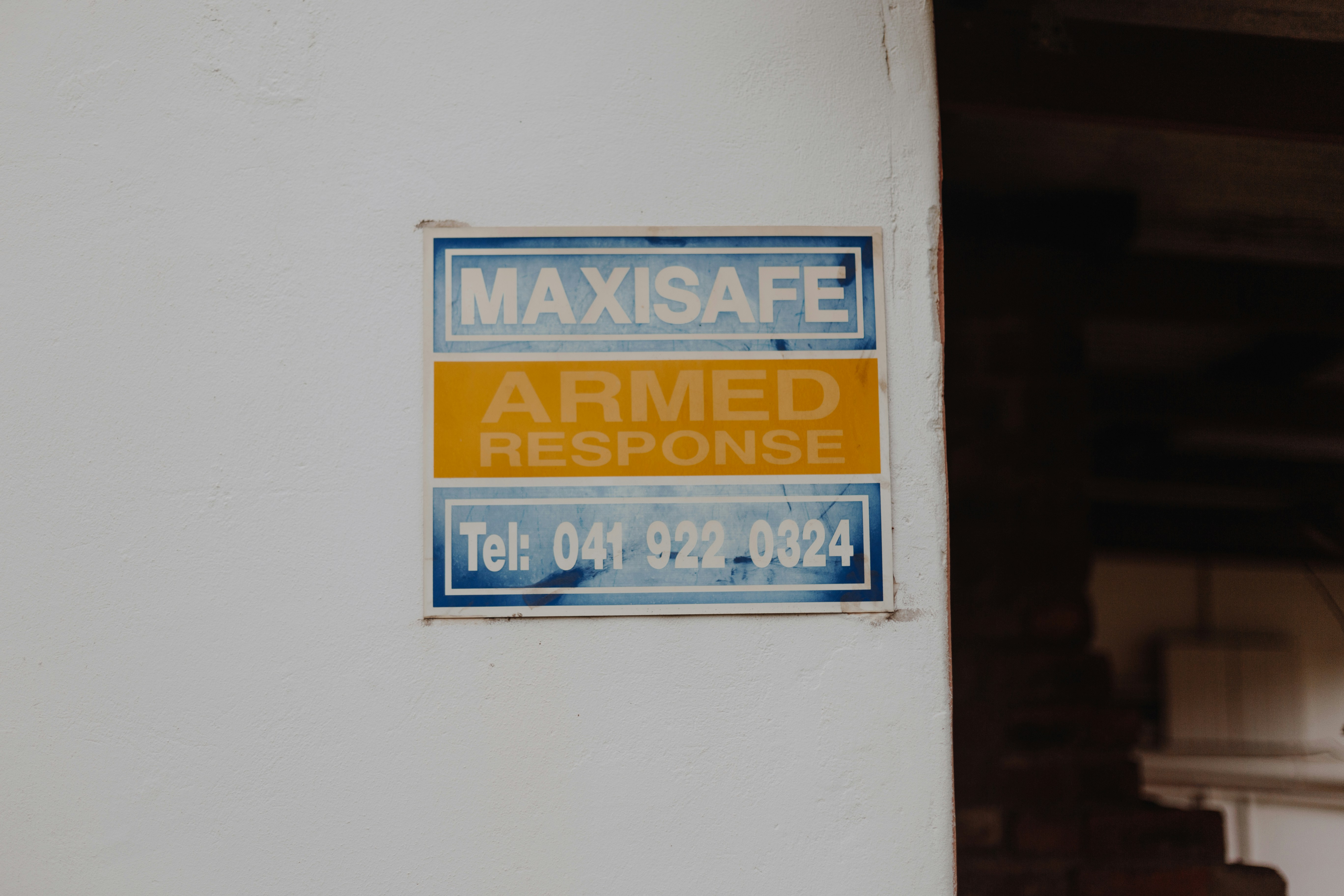 a blue and yellow sign on a white wall