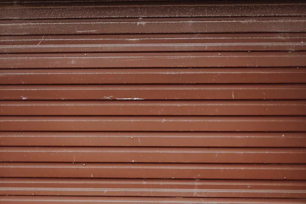 Pared de madera marrón con ventana de metal negro