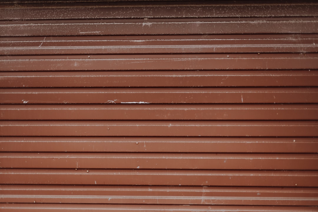 brown wooden wall with black metal window