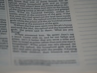 The image displays a close-up view of a page from a book or a document. The text is clearly visible on the left side with some portions being slightly out of focus, suggesting a macro or close-up photography style. The right side shows lines for notes or annotations. The text appears to be formatted in columns.
