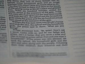 The image displays a close-up view of a page from a book or a document. The text is clearly visible on the left side with some portions being slightly out of focus, suggesting a macro or close-up photography style. The right side shows lines for notes or annotations. The text appears to be formatted in columns.