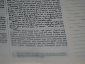 The image displays a close-up view of a page from a book or a document. The text is clearly visible on the left side with some portions being slightly out of focus, suggesting a macro or close-up photography style. The right side shows lines for notes or annotations. The text appears to be formatted in columns.