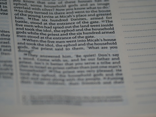 The image displays a close-up view of a page from a book or a document. The text is clearly visible on the left side with some portions being slightly out of focus, suggesting a macro or close-up photography style. The right side shows lines for notes or annotations. The text appears to be formatted in columns.