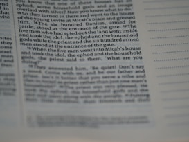 The image displays a close-up view of a page from a book or a document. The text is clearly visible on the left side with some portions being slightly out of focus, suggesting a macro or close-up photography style. The right side shows lines for notes or annotations. The text appears to be formatted in columns.