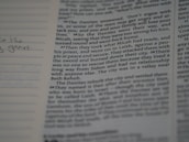 A close-up of an open book with handwritten notes and a pen resting on the pages.