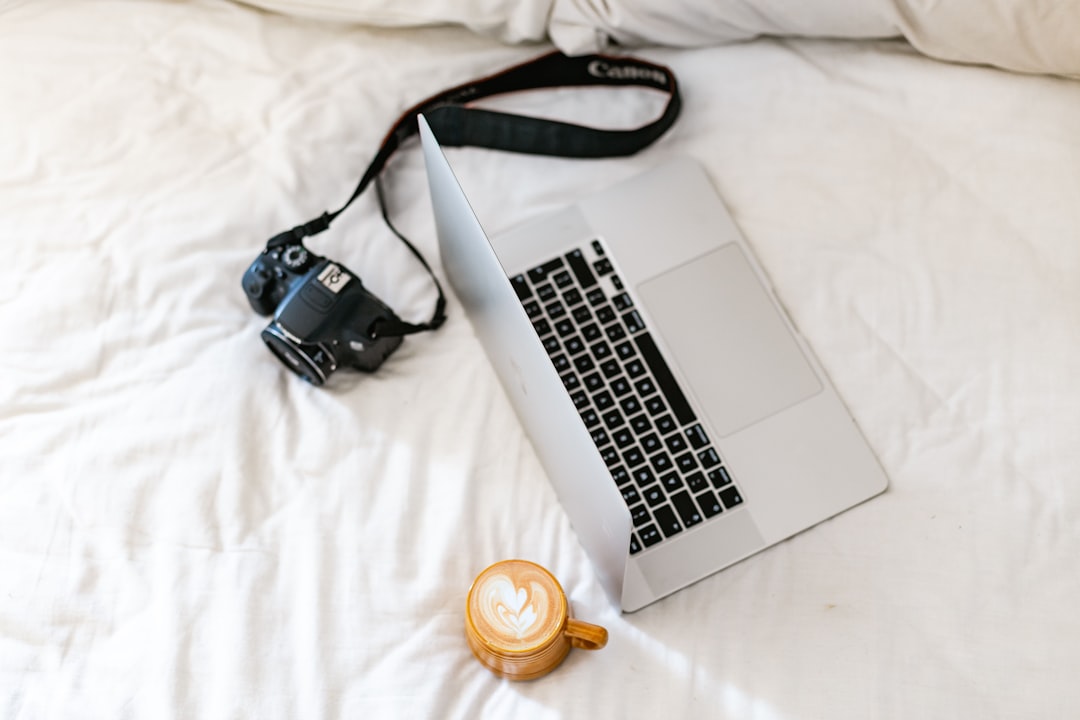 black dslr camera beside white ceramic mug on white textile