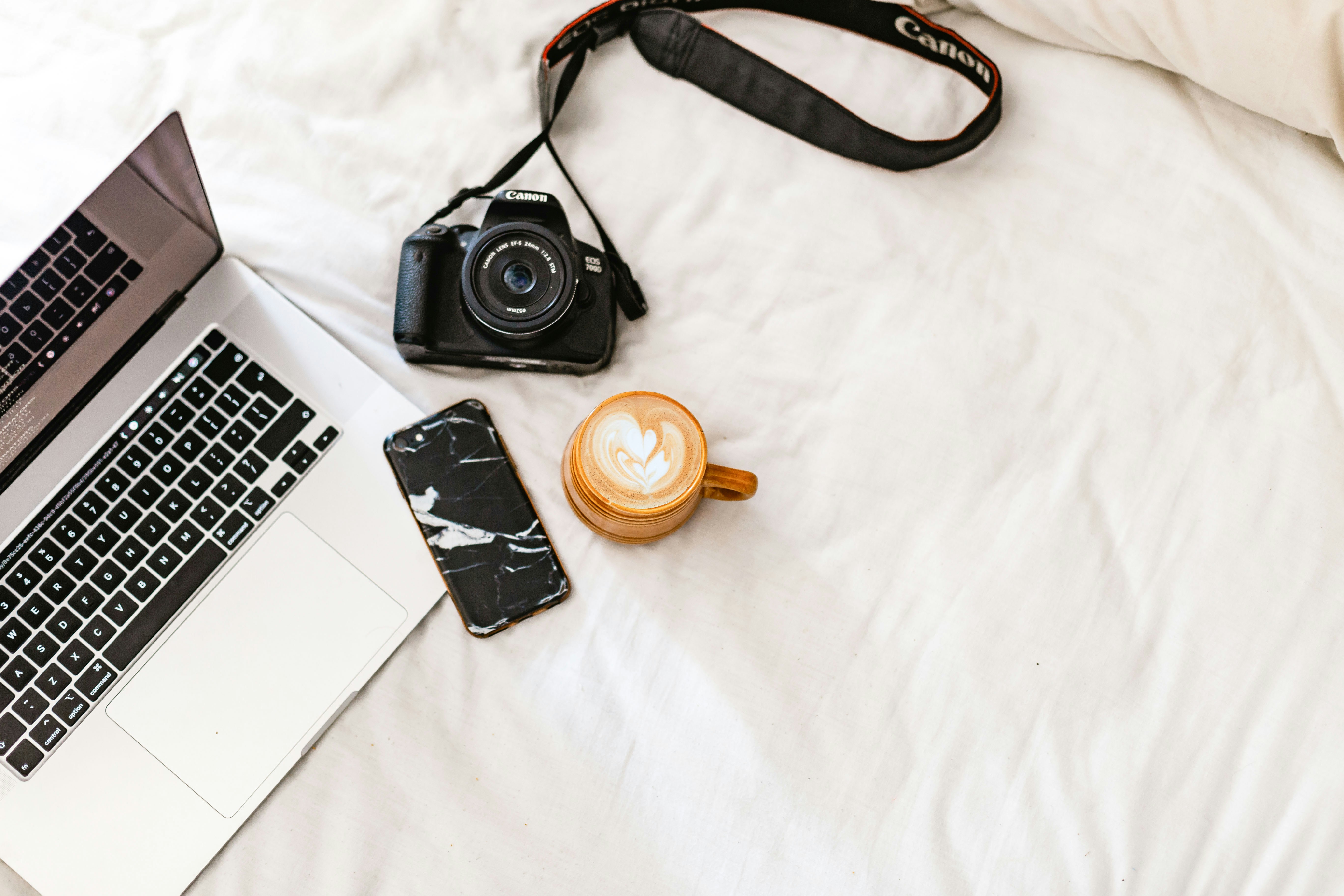 Black nikon dslr camera beside silver macbook pro photo Free Brown Image on Unsplash