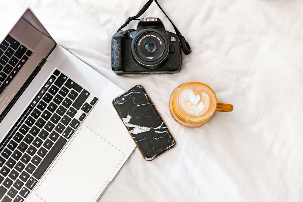 black nikon dslr camera beside macbook pro