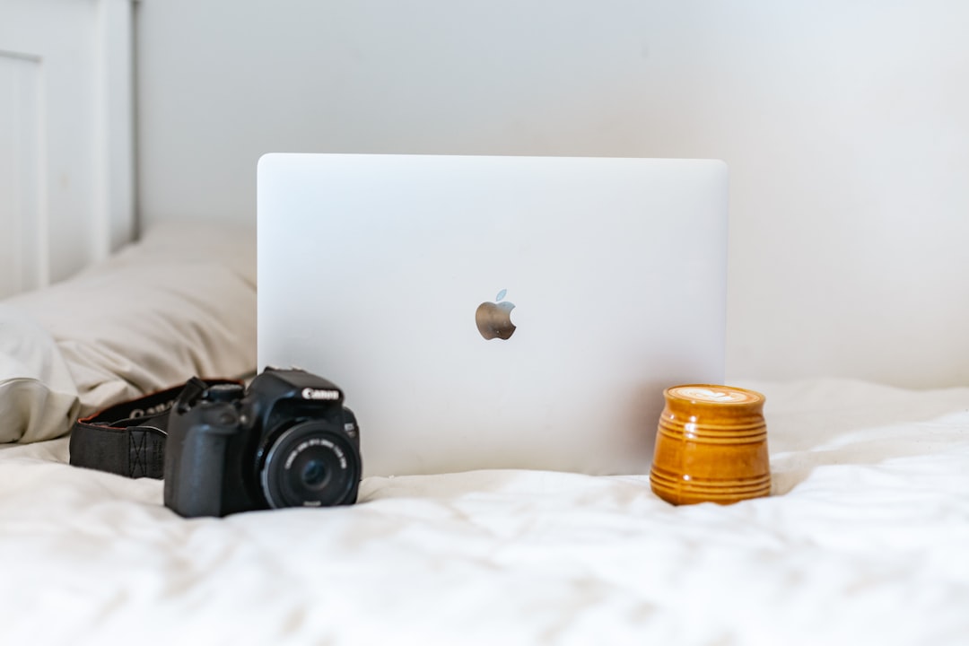 black nikon dslr camera beside silver macbook