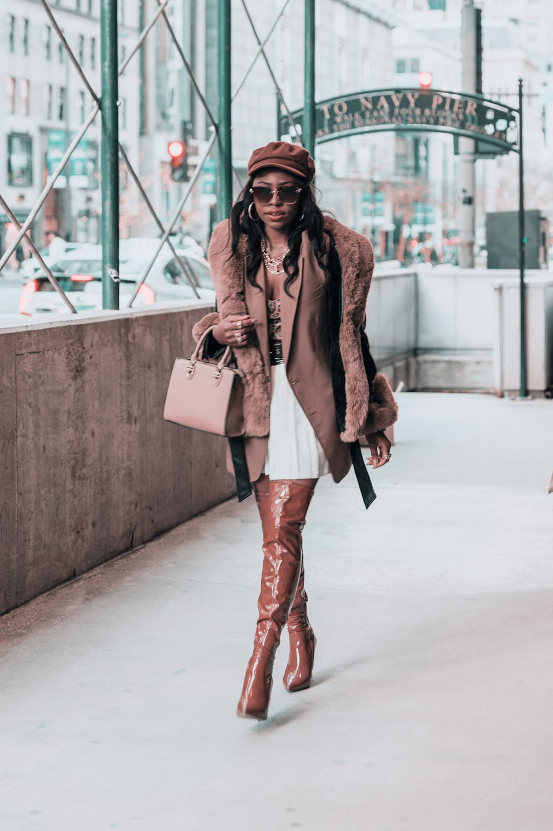 woman in brown leather jacket and black pants holding white leather sling bag