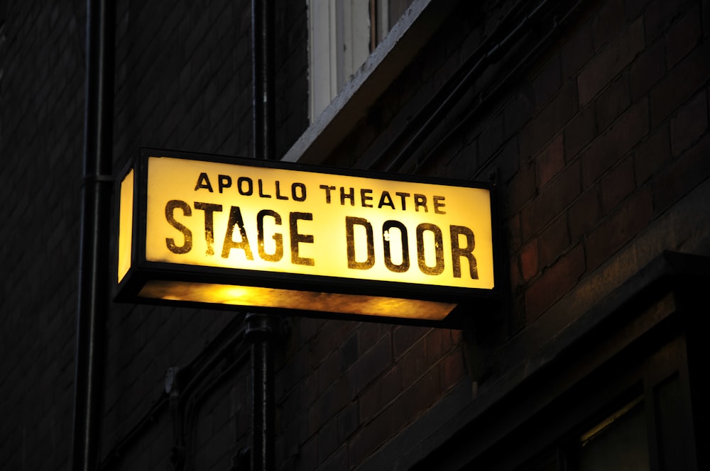 a yellow sign that says apollo theatre stage door
