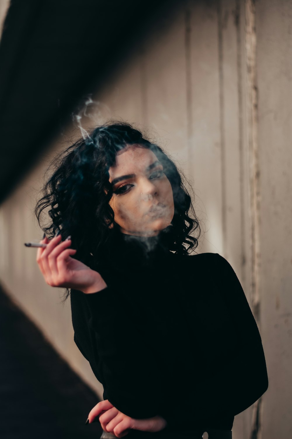 a woman smoking a cigarette with smoke coming out of her mouth