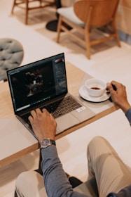 person using macbook pro on white table