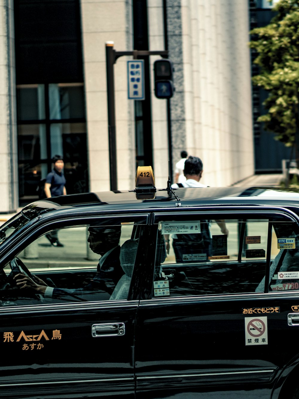 man in black jacket standing beside green car during daytime