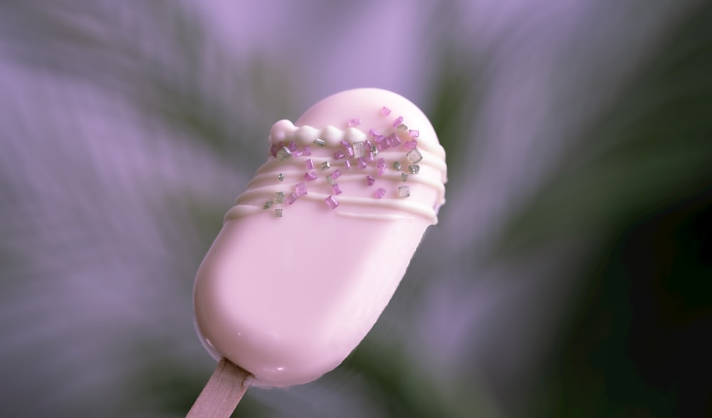 white heart shaped lollipop with pink sprinkles