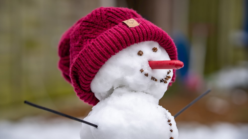 赤いニット帽と赤いニット帽をかぶった雪だるま