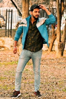 Man wearing a casual jacket standing outdoors in natural light.
