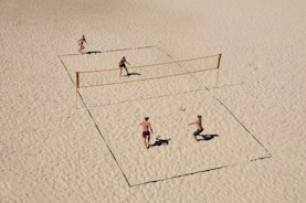 Outdoor sand courts with players enjoying beach tennis under the sun