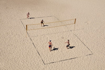 Volleyball players diving to save the ball on a sandy beach court