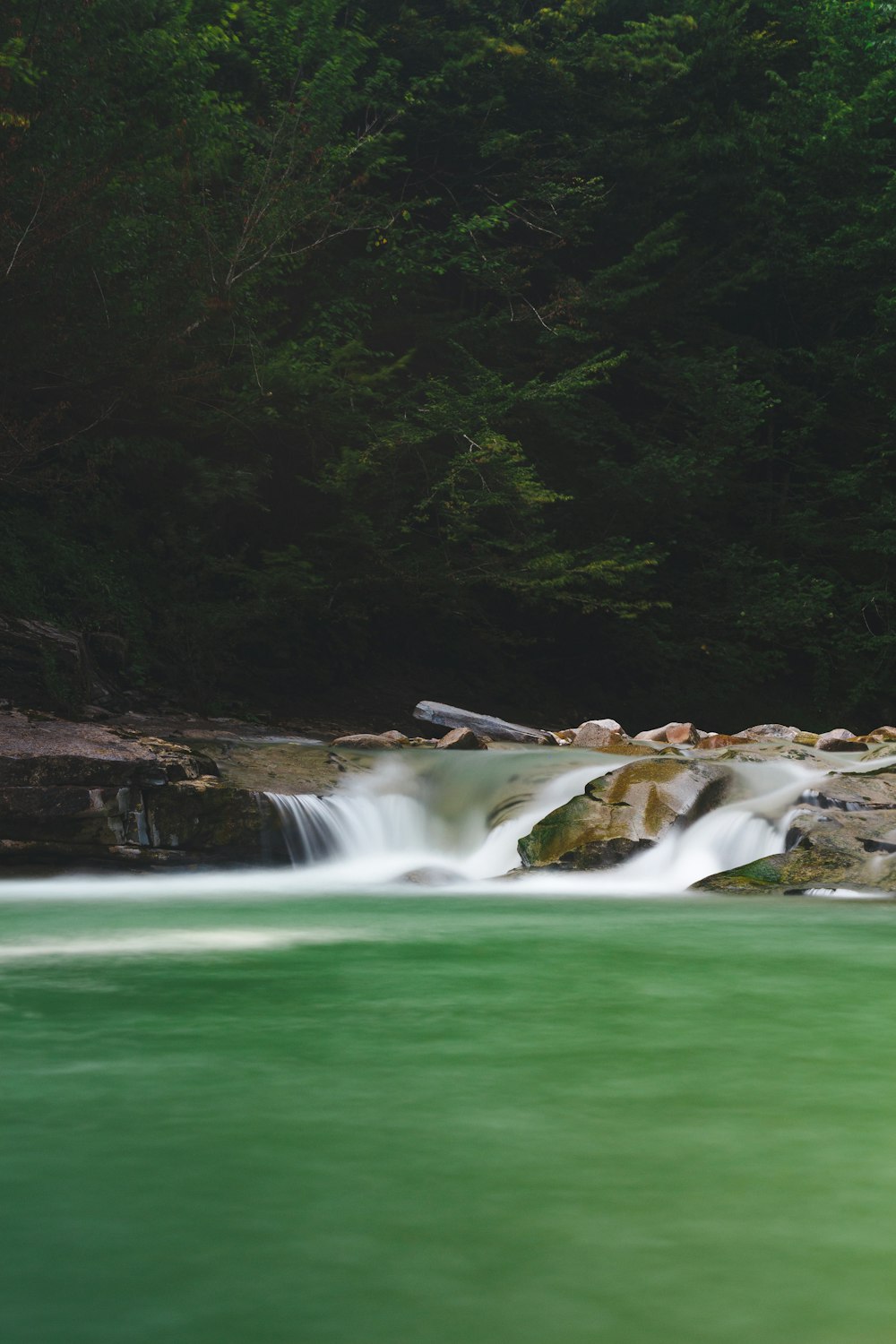 green water falls with brown rocks