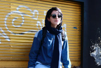 woman in blue jacket wearing black sunglasses