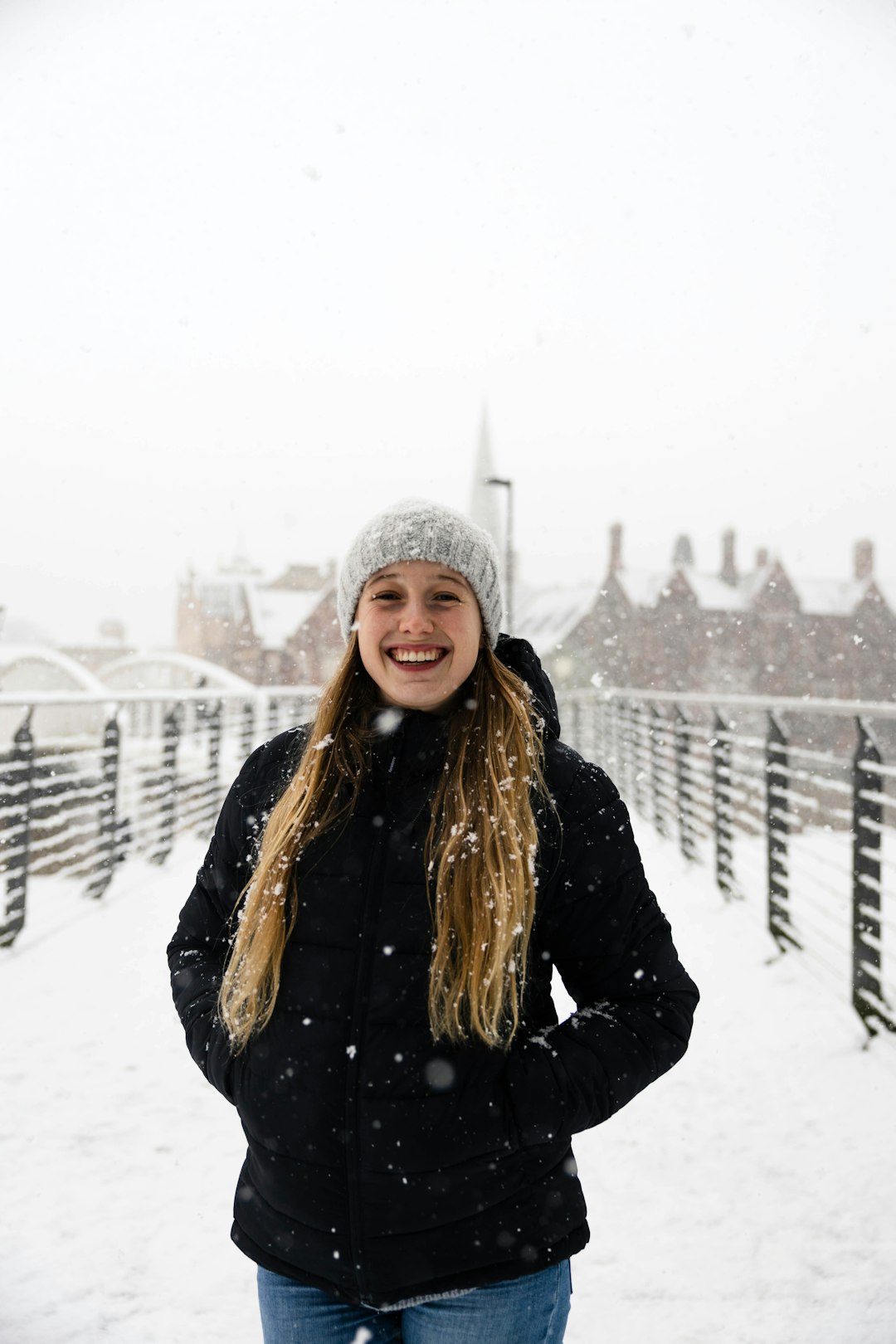 woman in black jacket standing on snow covered ground during daytime