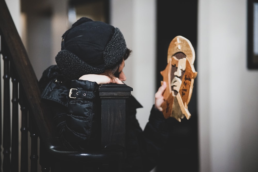 woman in black jacket holding brown book