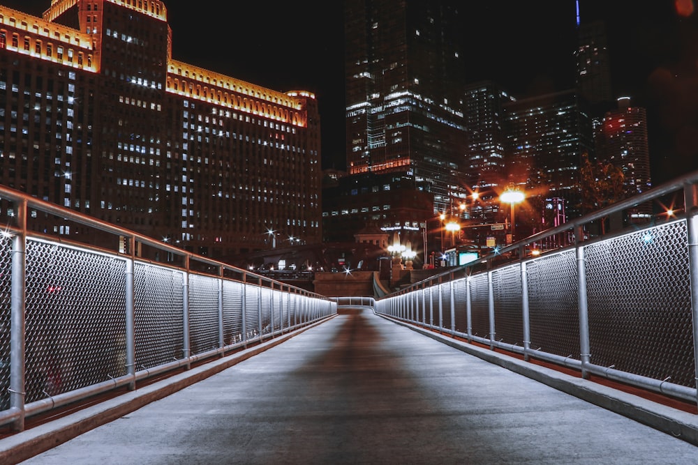 white metal fence near high rise building during night time