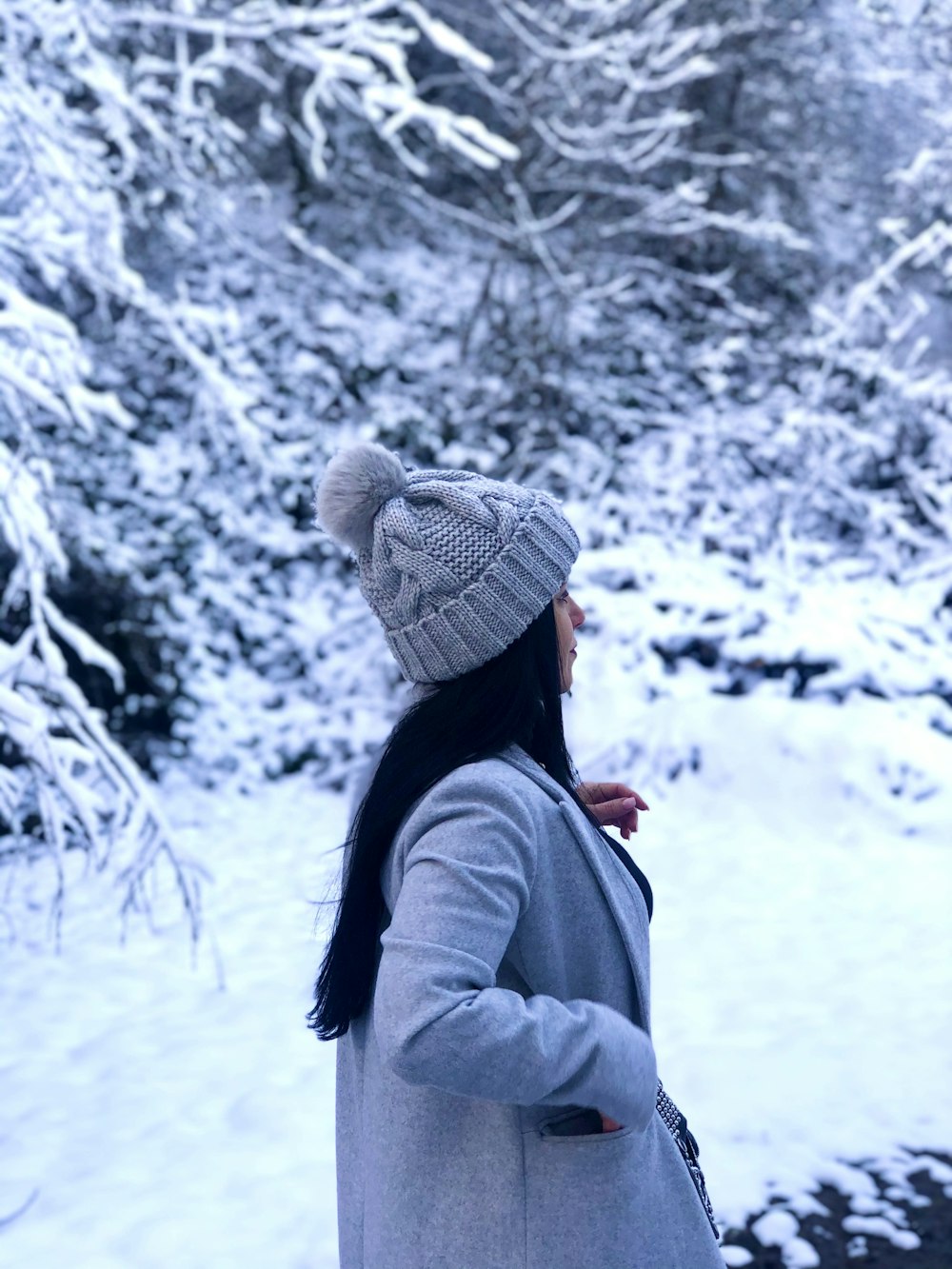 Mujer en la nieve con gorro blanco y jersey de lana azul. Stock Photo