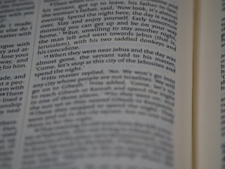 A close-up view of a page from a book, featuring printed text in English. The text is in a column format, with a focus that highlights certain words while others appear slightly blurred.