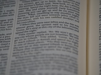 A close-up view of a page from a book, featuring printed text in English. The text is in a column format, with a focus that highlights certain words while others appear slightly blurred.