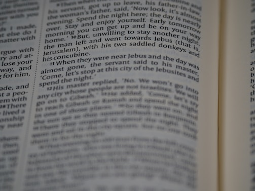 A close-up view of a page from a book, featuring printed text in English. The text is in a column format, with a focus that highlights certain words while others appear slightly blurred.