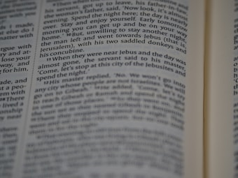 A close-up view of a page from a book, featuring printed text in English. The text is in a column format, with a focus that highlights certain words while others appear slightly blurred.