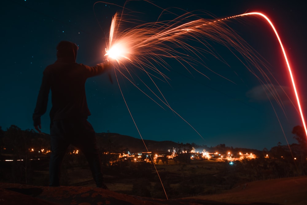 man holding fire cracker during night time