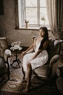 Luxurious silk nightgown draped over a vintage armchair in a sunlit room