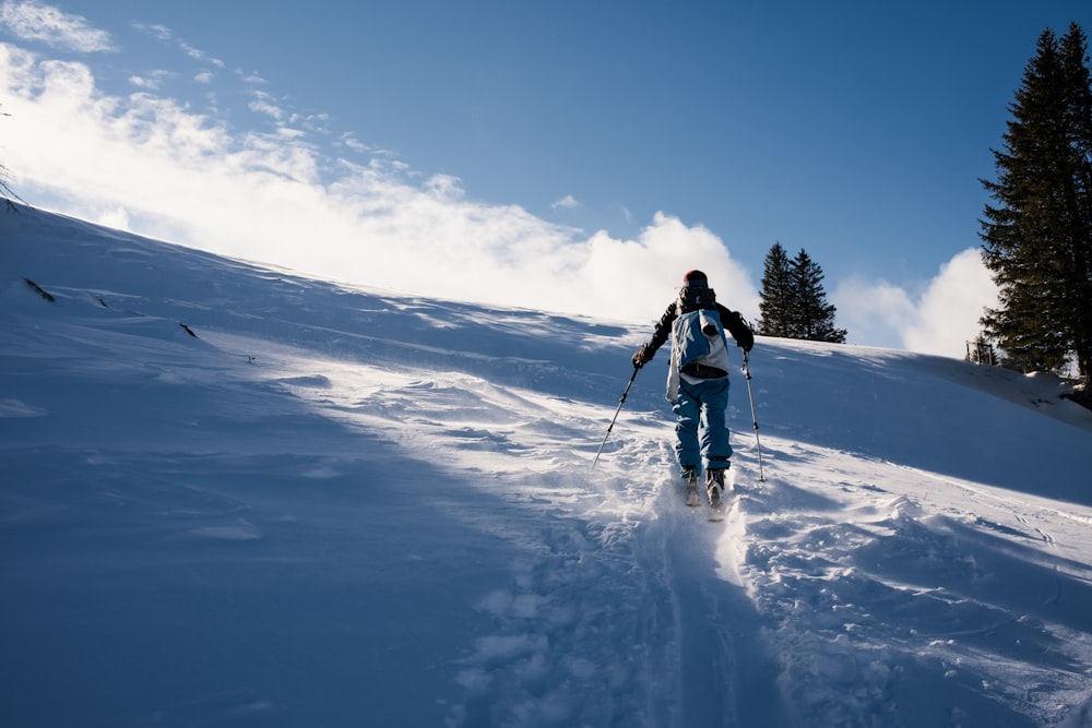 person in white jacket and black pants standing on snow covered ground during daytime