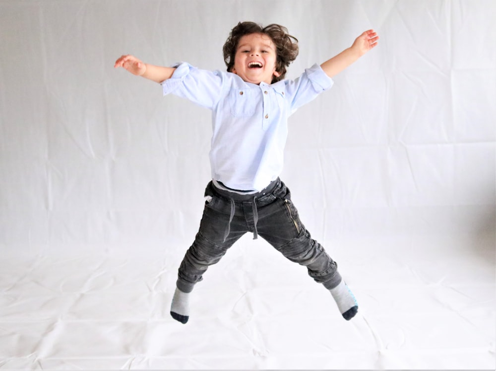 Foto chica con camisa de vestir blanca y pantalón negro saltando – Imagen  #niños gratis en Unsplash