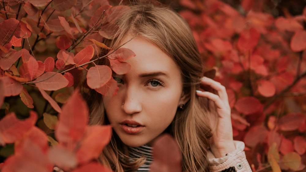 woman in white shirt lying on red leaves