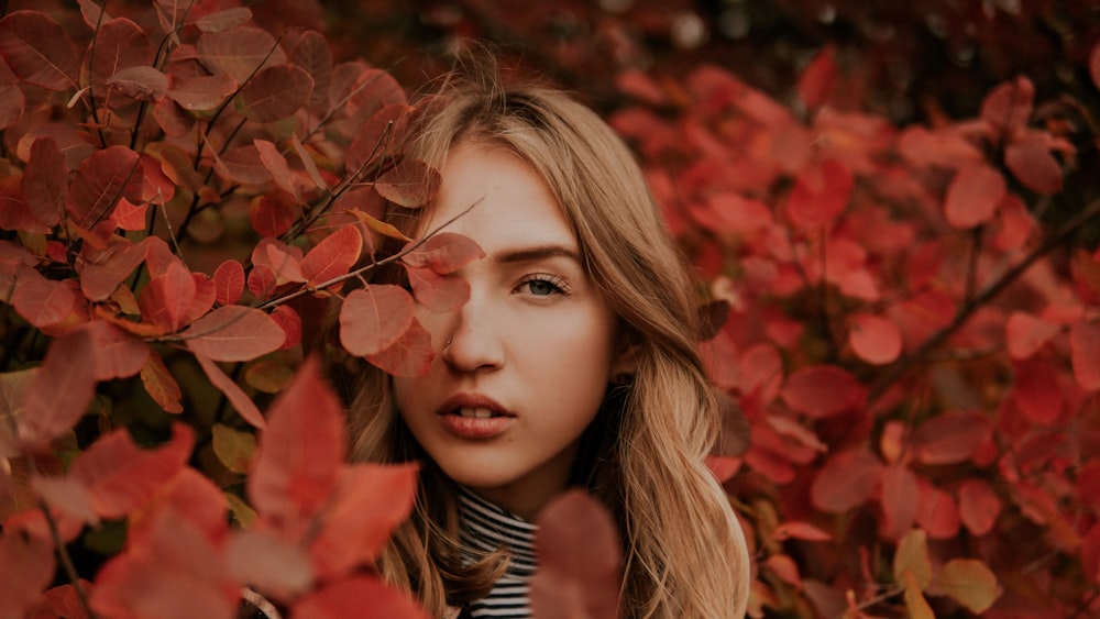 woman in red leaves during daytime