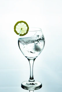 A refreshing splash of Primewave pouring into a glass with ice cubes.