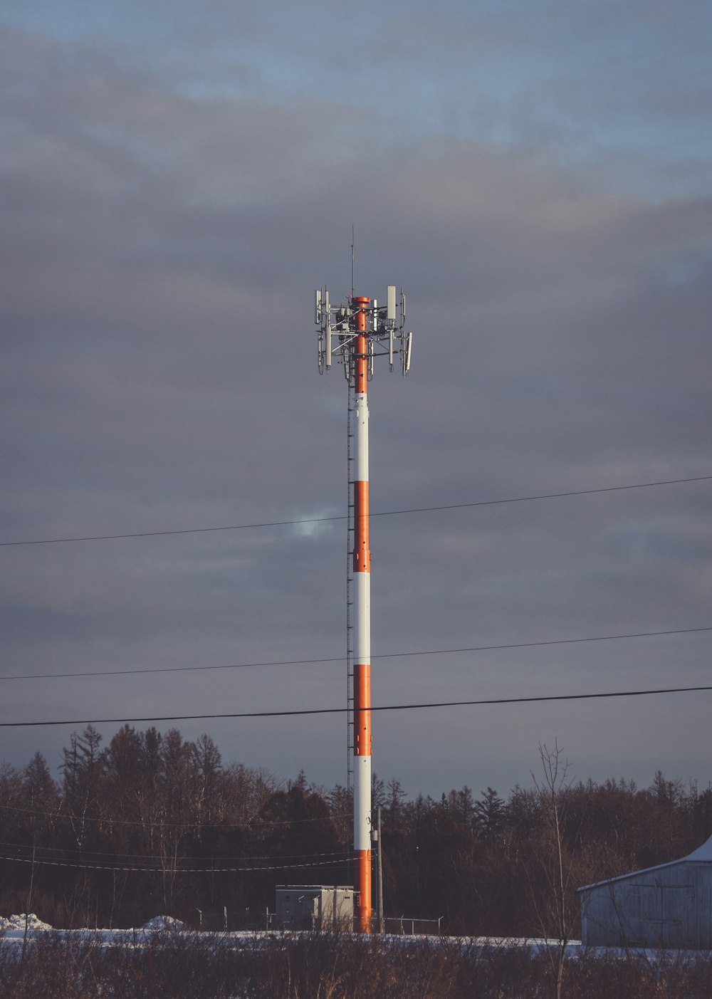 white and red metal post under gray clouds