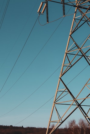 brown electric post under blue sky during daytime