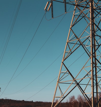 brown electric post under blue sky during daytime