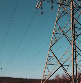 brown electric post under blue sky during daytime