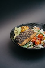 grilled meat with green vegetable on black ceramic plate