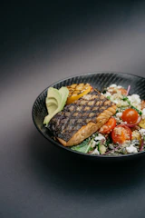 grilled meat with green vegetable on black ceramic plate