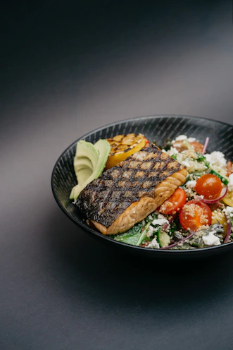 grilled meat with green vegetable on black ceramic plate